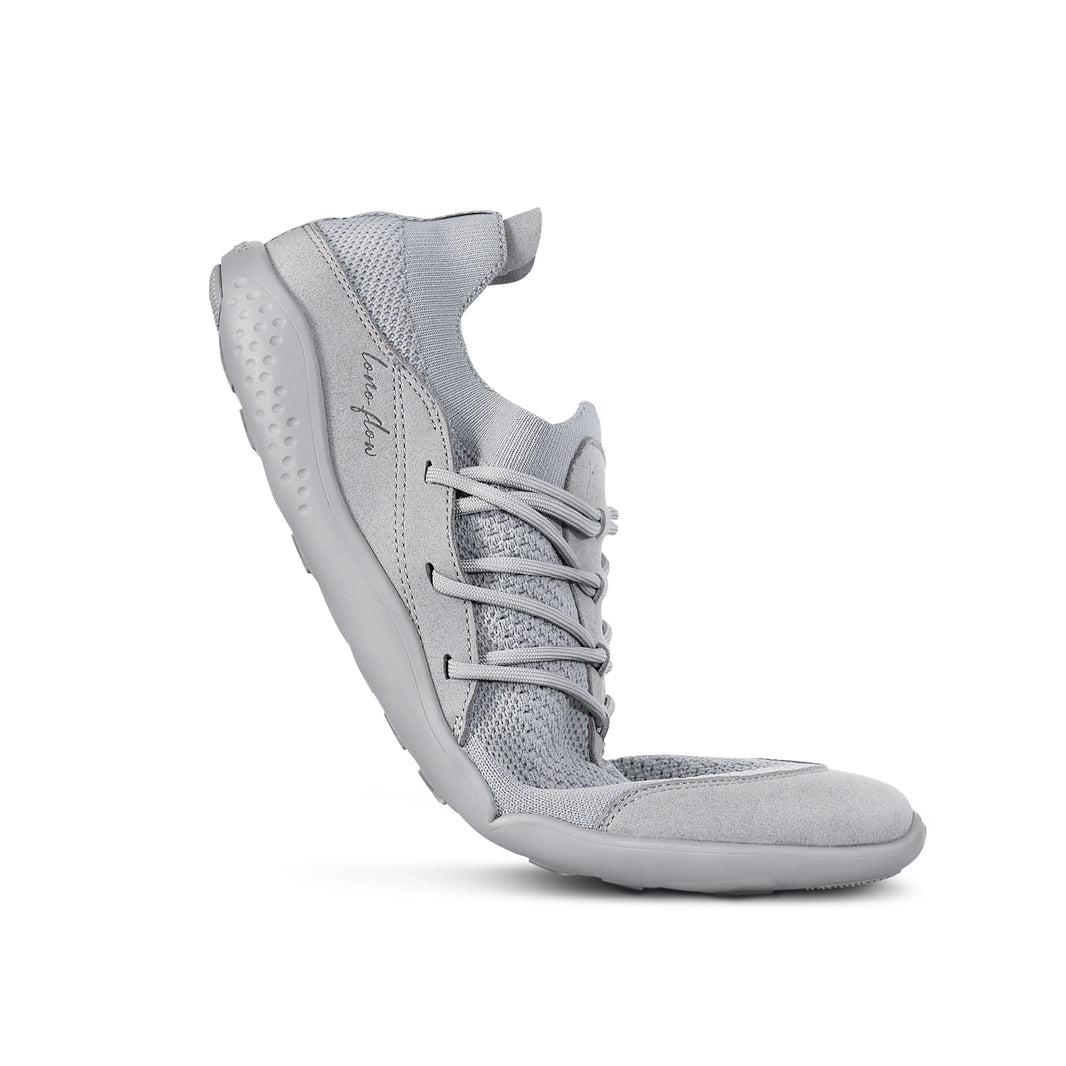 Grey LONO FLOW barefoot shoe bent to show sole flexibility