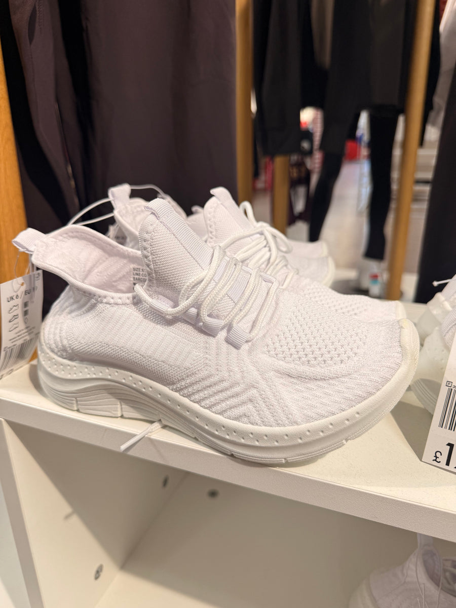 Conventional trainer resting on a shop shelf showing elevated heel wedge and upward toe spring curve