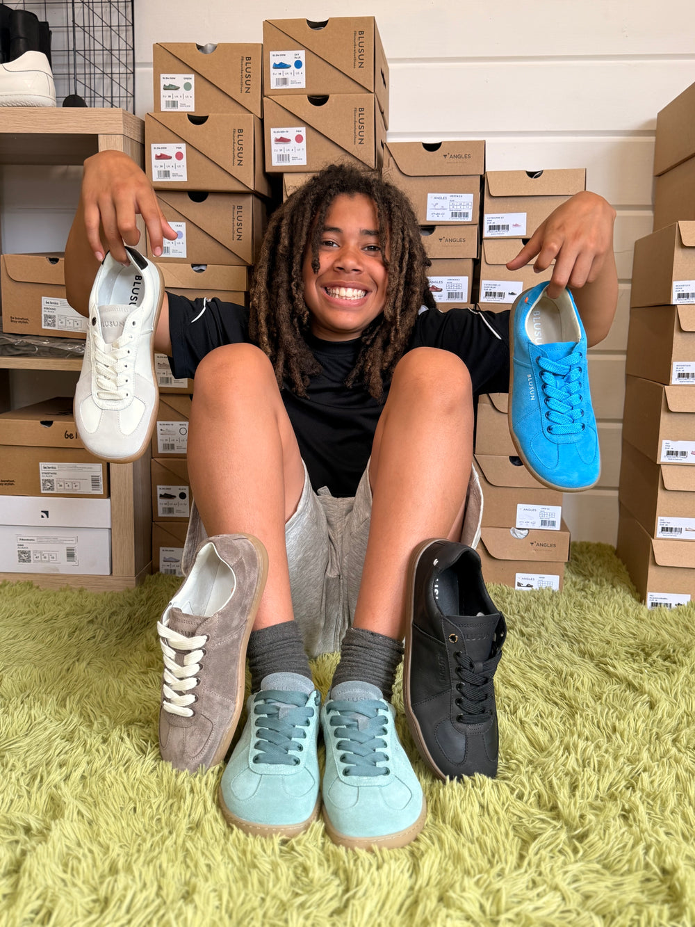 One of the Adams children with BLUSUN barefoot shoes and boxes at BarefootBrit Shop