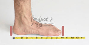 Side view of bare foot on measuring tape for barefoot shoe sizing