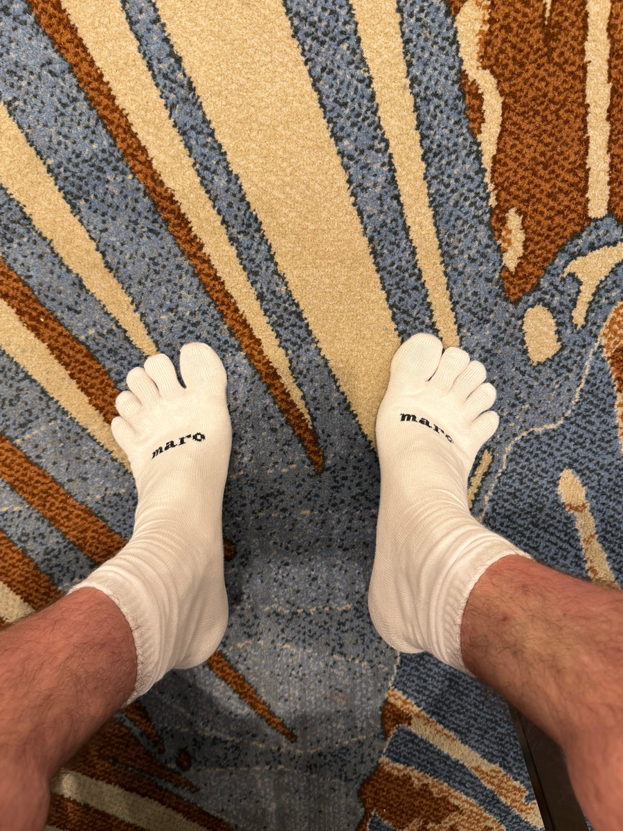 Maro white five-toe socks being worn on feet, showing individual toe separation
